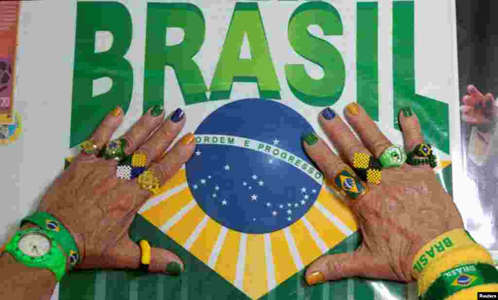 Marilza Guimarães da Silva, tem as unhas pintadas com as cores do Brasil e usa anéis alusivos à selecção. Não deve haver maior fã da equipa canarina. Brasília, Maio 27, 2014. REUTERS/Joedson Alves 