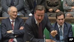 英国首相卡梅伦(中)12月12日在伦敦的议会辩论中