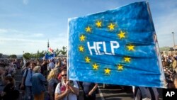 Supporters of Hungary's political opposition display a banner during an anti-government protest in Budapest, Hungary, May 21, 2017. At least 5,000 protesters marched in downtown Budapest, calling on the government to repeal legal amendments which could force Central European University out of the country.