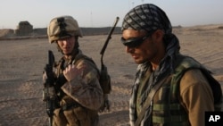 FILE - U.S. Marine 1st Lt. Zachary Bennett talks with an Afghan interpreter during a joint patrol in Helmand province, southern Afghanistan, Sept. 19, 2009. 