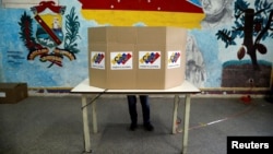 Una persona deposita su voto para las primarias del partido del Gobierno, de cara a las elecciones de noviembre, en Caracas, el 8 de agosto de 2021.