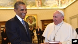 Paus Fransiskus (kanan) dan President Barack Obama saling memberikan hadiah dalam pertemuan di Vatikan (27/3).