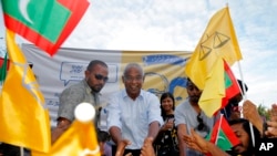 FILE - Ibrahim Mohamed Solih (C), the president-elect of the Maldives, interacts with his supporters during a gathering in Male, Maldives, Sept. 24, 2018. He has secured a majority in Parliament after the Elections Commission restored 12 lawmakers who were earlier deemed to have lost their seats.