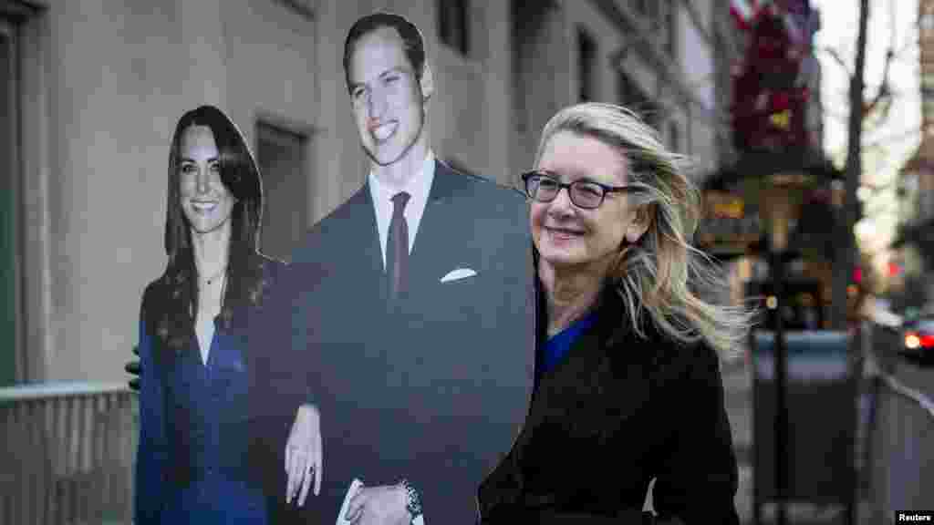 Un résident détient une effigie découpée du duc et de la duchesse de Cambridge, le prince William et sa femme, Catherine, devant l'Hôtel Carlyle à New York, le 7 décembre 2014.