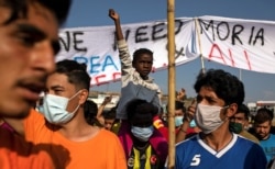 Refugees and migrants from the destroyed Moria camp protest after the news about the creation of a new temporary camp, on the island of Lesbos, Greece, Sept. 12, 2020.