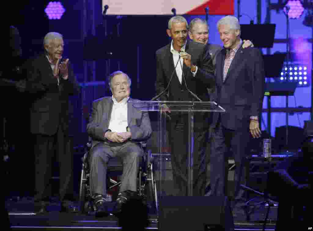 Former President Barack Obama, speaks as fellow former Presidents, from left, Jimmy Carter, George H.W. Bush, George W. Bush, and Bill Clinton look on during a hurricanes relief concert in College Station, Texas, Oct. 21, 2017.