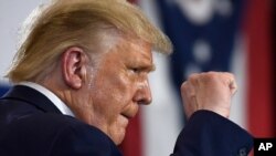 El presidente Donald Trump alza el puño al concluir un discurso en Clyde, Ohio, el 6 de agosto.