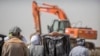 FILE - Ethiopian relatives of crash victims mourn as a mechanical digger operates at the scene where the Ethiopian Airlines Boeing 737 Max 8 crashed shortly after takeoff killing all 157 on board, near Bishoftu, southeast of Addis Ababa, in Ethiopia, March 10, 2019. 