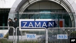 Riot police officers walk by the headquarters of Zaman newspaper in Istanbul. Turkey shuts down scores of media outlets, July 27, 2016, in what appeared to be a widening crackdown following the failed coup against President Recep Tayyip Erdogan's government.