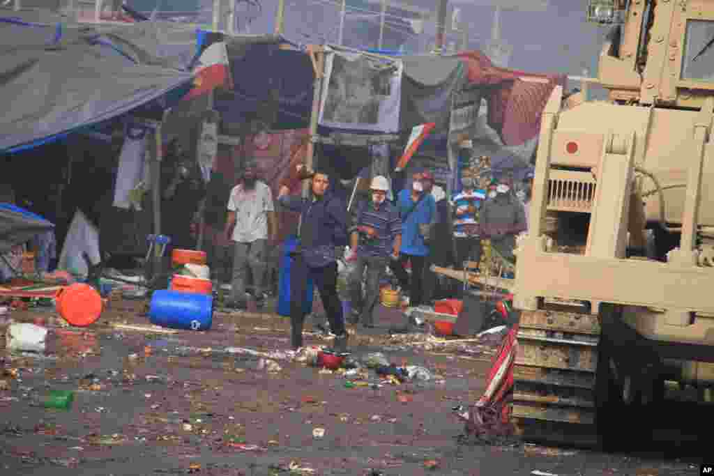 Para demonstran melempar batu pada pasukan keamanan Mesir yang mencoba membubarkan aksi duduk pendukung presiden terguling Mohamed Morsi di Kairo (14/8). (AP/Ahmed Gomaa)