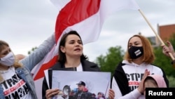 La líder opositora bielorrusa Sviatlana Tsikhanouskaya con una foto de su esposo detenido durante una protesta contra el gobierno del presidente Alexander Lukashenko en Vilna, Lituania, el 29 de mayo de 2021.
