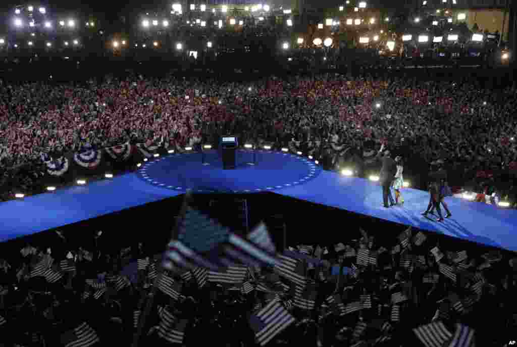 President Barack Obama walks on stage with first lady Michelle Obama and daughters Malia and Sasha at his election night party November 7, 2012, in Chicago, Illinois.