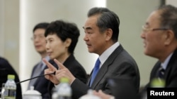 Chinese State Councilor and Foreign Minister Wang Yi (2-R) speaks during a meeting with Myron Brilliant, executive vice president and head of International Affairs at the U.S. Chamber of Commerce (not pictured) at the Ministry of Foreign Affairs in Beijing, China, Feb. 19, 2019.