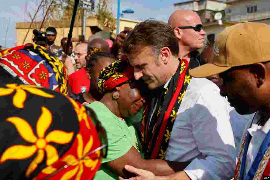 France's president Emmanuel Macron embraces a woman as he speaks with local residents during his visit at the kavani district in Mamoudzou, on the French Indian Ocean territory of Mayotte, aftermath of the cyclone Chido.