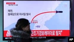 Una mujer en una estación de tren en Seúl, Corea del Sur, pasa frente a una pantalla de televisión donde se ve uninforme sobre la prueba misilística norcoreana el lunes, 6 de marzo, de 2017.
