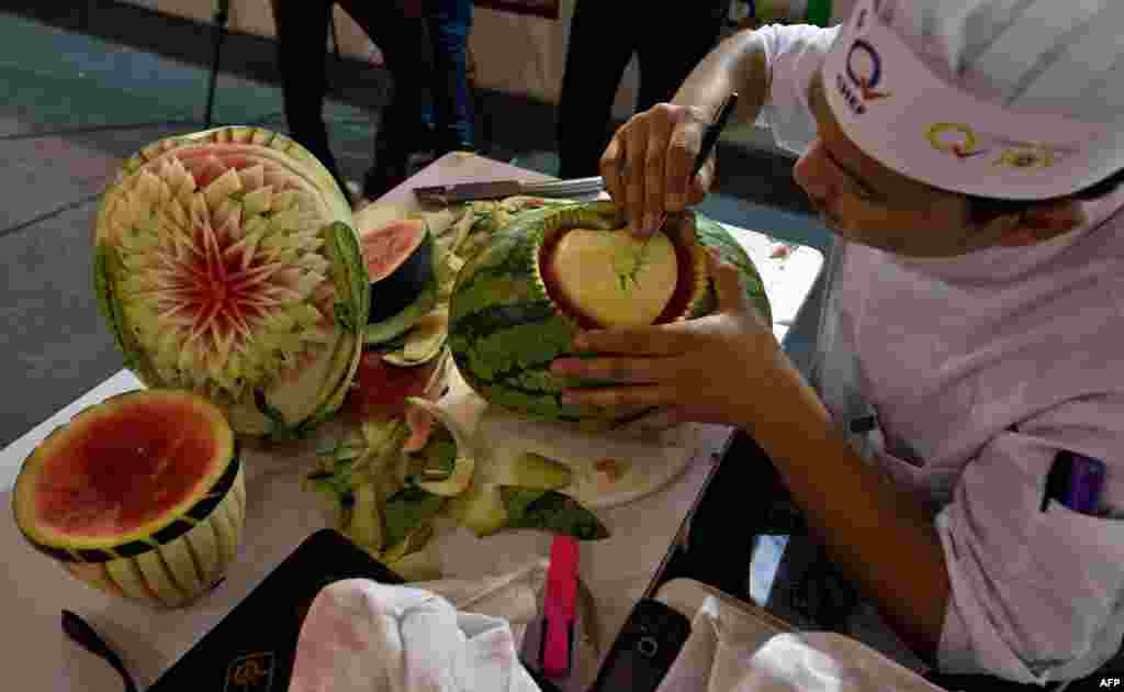 Seorang koki India mengukir buah semangka dalam lomba kuliner di distrik Pragati Maidan, New Delhi, India. 