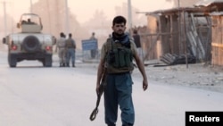 Seorang polisi Afghanistan tiba di lokasi serangan di kota Jalalabad (30/8).