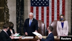 FILE - U.S. Vice President Mike Pence hands the West Virginia certification to staff as Speaker of the House Nancy Pelosi listens, during a joint session of Congress, Jan. 7, 2021.