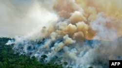 (FILES) In this file photo taken on August 16, 2020, aerial view of a burning area of Amazon rainforest reserve, south of Novo Progresso in Para state, Brazil. - Rampant fires in the Amazon are "poisoning the air" of the world's biggest rainforest,…