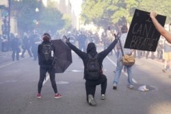 Demonstrators in front of a line of police officers during a protest for the death of George Floyd, June 1, 2020, near the White House in Washington.