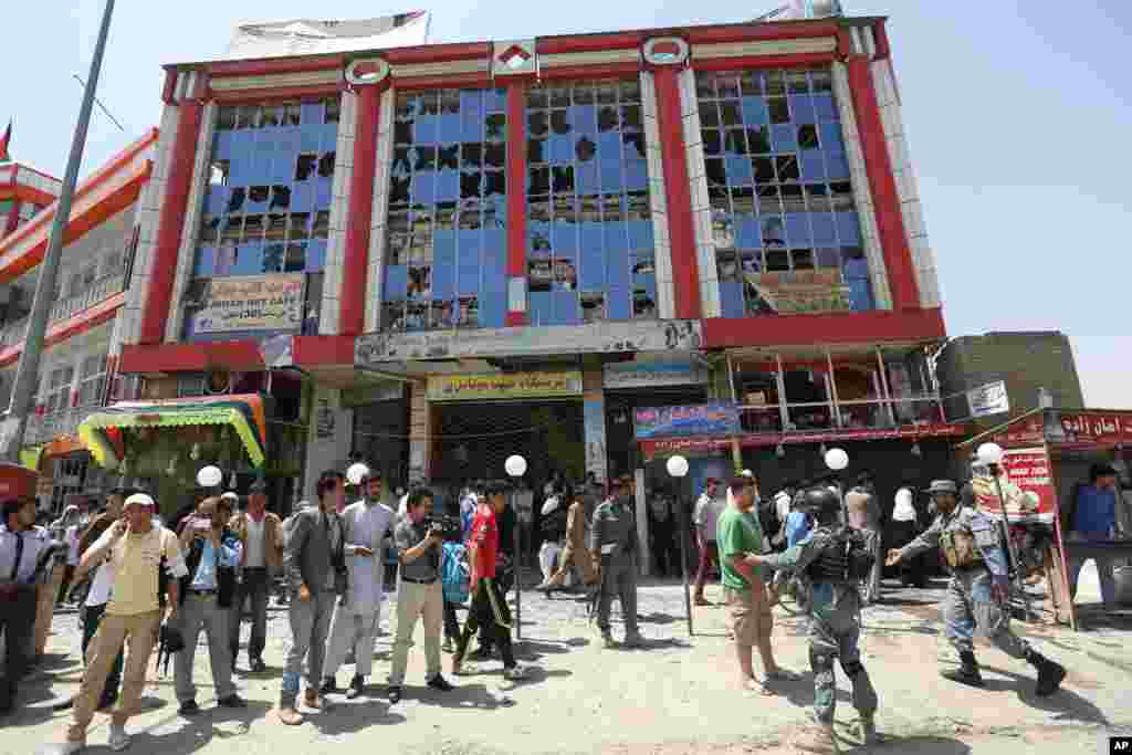 Afghans gather in front of a shopping mall near the site of a suicide attack in Kabul, Afghanistan, Aug. 10, 2014.