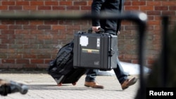 FILE - An inspector from the Organization for the Prohibition of Chemical Weapons (OPCW) arrives to begin work at the scene of the nerve agent attack on former Russian spy Sergei Skripal and his daughter, in Salisbury, Britain, March 21, 2018. 
