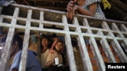 Muslim people pass the time at their house in Paik Thay, the site of recent violence between Muslim Rohingyas and Buddhist Rakhine people in Burma, November 2, 2012.