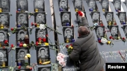 A man takes part in a commemoration ceremony, Nov. 21, 2019, at a monument to the "Heavenly Hundred," the anti-government protesters killed during the Ukrainian pro-European Union mass demonstrations in 2014, to mark the sixth anniversary of the uprising.