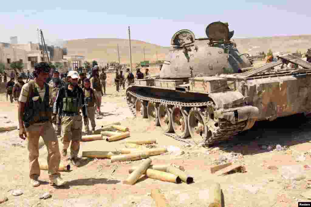 Para anggota Tentara Pembebasan Suriah memeriksa amunisi dan tank milik pasukan pemerintahan Presiden Bashar al-Assad setelah merebut kota Khanasir (26/8).