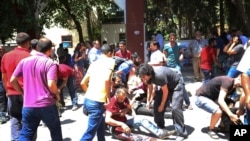 Gente ayudando a los heridos tras la explosión en Suruc, Turquía, el lunes, 20 de julio de 2015.