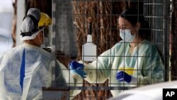Medical staff prepare to take coronavirus tests at a drive-thru community-based assessment center in Christchurch, New Zealand, Aug. 13, 2020.