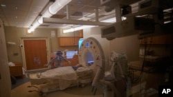 Charlie Stroiney, 8, is prepped for an MRI during a long day of testing at Children's National Hospital, in Washington. Charlie did not have COVID-19 but her sister, Lexie, 6, did.
