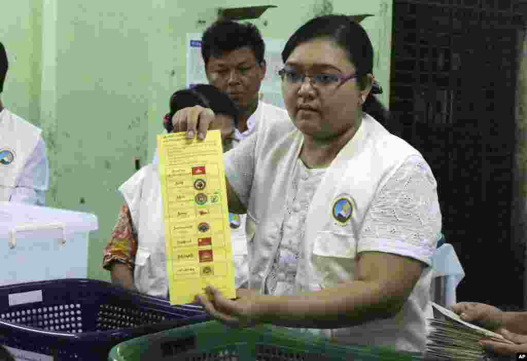 Petugas komisi pemilihan umum Myanmar menunjukkan sebuah surat suara saat menghitung suara di TPS dalam pemilu negara tersebut di Yangon, 8 November 2015.