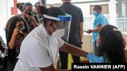 Un agent de santé injecte la première dose du vaccin produit par Sinopharm à l'hôpital des Seychelles à Victoria, le 10 janvier 2021.