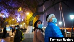 Duan Ling, 36, and her husband, Fang Yushun, walk on a street, almost a year after the global outbreak of the coronavirus disease (COVID-19) in Wuhan, Hubei province, China, Dec. 16, 2020. 