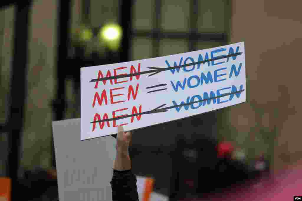 Protesters hold up signs ahead of the Women's March on Washington a day after Donald Trump's inauguration as President of the United States of America, January 21, 2017 (B. Allen / VOA)