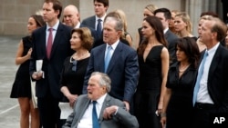 Former President George W. Bush and his father former President George H.W. Bush watch as the casket of former first lady Barbara Bush is loaded into a hearse at St. Martin's Episcopal church, April 21, 2018, in Houston