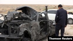 A fighter loyal to Libya's internationally recognised government checks a damaged vehicle after taking control of al-Watiya airbase, southwest of Tripoli, Libya, May 18, 2020.
