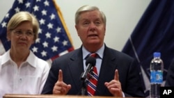FILE - U.S. Senator Lindsey Graham speaks during a press conference at the Resolute Support headquarters in Kabul, Afghanistan, July 4, 2017. Senator Elizabeth Warren, left, also made the trip.