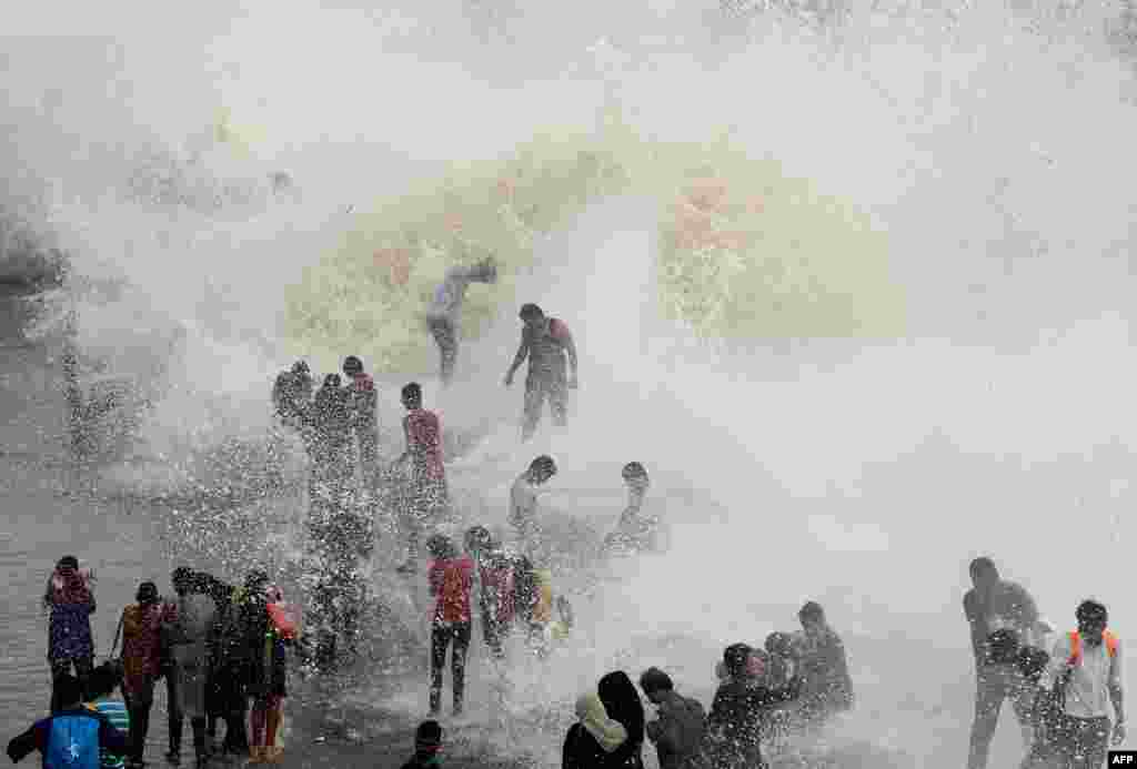 在印度孟买,涨潮时分,人们在海边迎接海浪(6月28日)