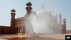 Volunteers disinfects the historical Badshahi Mosque ahead of the Muslim fasting month of Ramadan, in Lahore, Pakistan, April 22, 2020. 