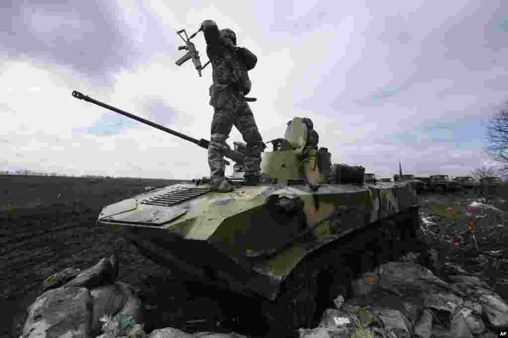 Seorang tentara Ukraina berdiri di atas kendaraan militernya di kota Michurino, Ukraina.