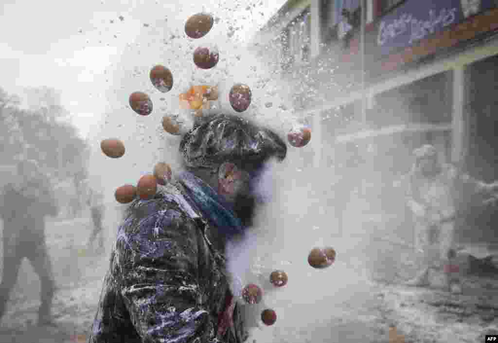 Revellers dressed in mock military garb take part in "Els Enfarinats" flour-battle in the southeastern Spanish town of Ibi, Dec. 28, 2024.