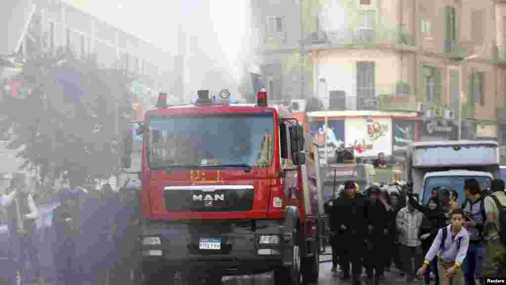 Riot police fire a water cannon to disperse people protesting a new law restricting demonstrations, in downtown Cairo, Nov. 26, 2013.