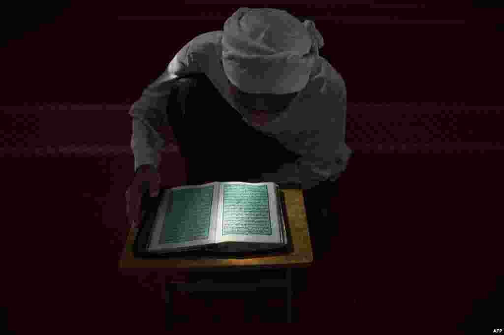 Seorang siswa Malaysia membaca Quran pada bulan Ramadan di Hulu Langat, dekat Kuala Lumpur.