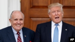 FILE - Then-President-elect Donald Trump calls out to media as he and former New York Mayor Rudy Giuliani pose for photographs at the Trump National Golf Club Bedminster clubhouse in Bedminster, N.J., Nov. 20, 2016.