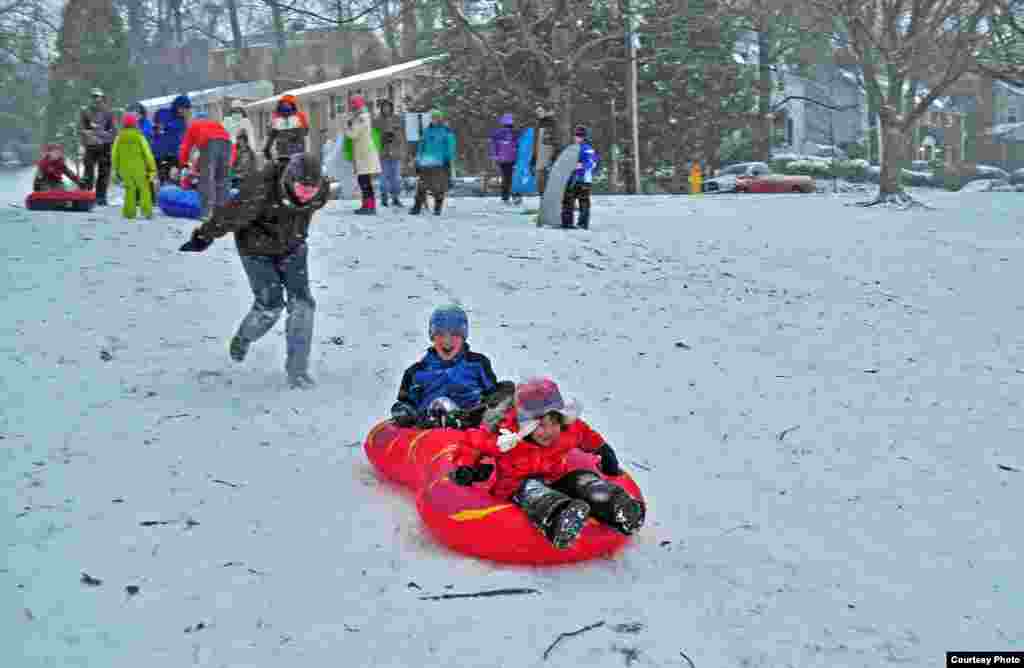 Children sled in a snow-covered park during a snow storm in Crystal City, Arlington, Virginia, Jan. 21, 2014. (Photo taken by Dimitris Mantis/VOA Greek Service)