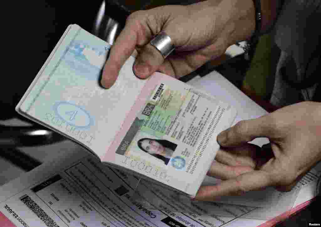 Estando todavía en el aeropuerto de La Habana, Yoani Sánchez muestra su visa brasileña impresa en su pasaporte cubano, con lo que puede hacer realidad muchos de sus sueños.