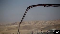 Palestinian men work on a construction site in the West Bank Jewish settlement of Maale Adumim, near Jerusalem, 14 Nov 2010