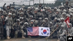 FILE - U.S. and South Korean army soldiers pose on a floating bridge on the Hantan River during a joint military exercise against a possible attack from North Korea, in Yeoncheon, South Korea, Dec. 10, 2015. 